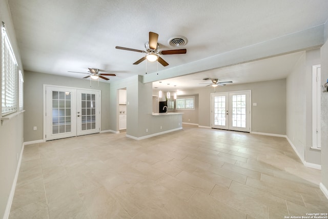 unfurnished living room featuring light tile patterned flooring, a textured ceiling, french doors, and ceiling fan