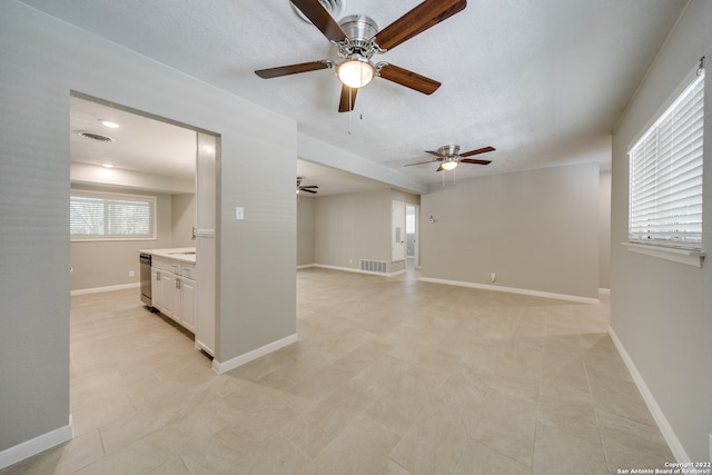 tiled spare room with ceiling fan