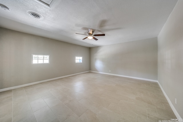 spare room with light tile patterned floors, a textured ceiling, and ceiling fan