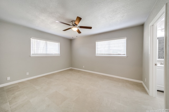 tiled empty room featuring a textured ceiling, ceiling fan, and plenty of natural light