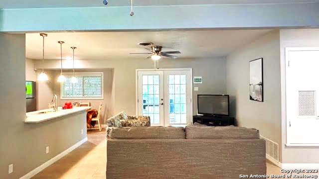 living room with ceiling fan, sink, french doors, and light hardwood / wood-style flooring