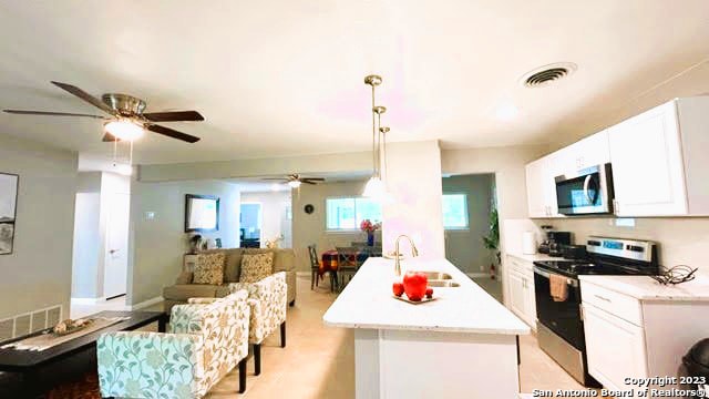 kitchen with white cabinetry, appliances with stainless steel finishes, sink, and ceiling fan