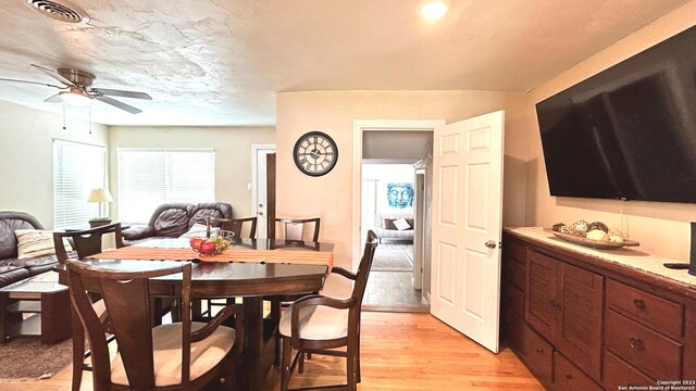 dining space with light hardwood / wood-style floors and ceiling fan