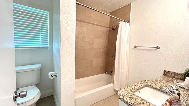 full bathroom featuring vanity, shower / bath combo, toilet, a textured ceiling, and tile patterned flooring