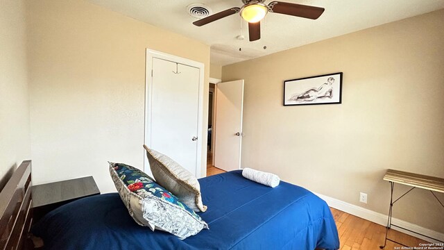 bedroom with light hardwood / wood-style flooring, a closet, and ceiling fan