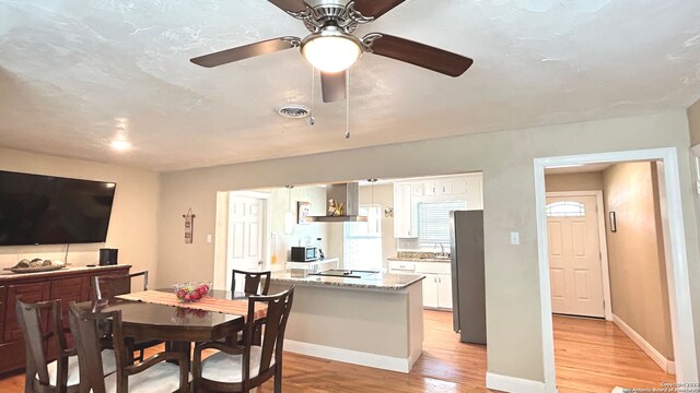 dining area featuring sink, ceiling fan, and light hardwood / wood-style floors