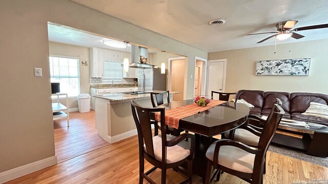 dining space with light hardwood / wood-style flooring and ceiling fan