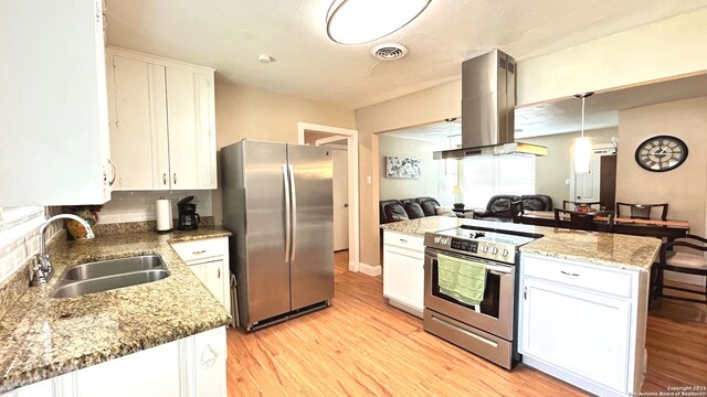 kitchen featuring white cabinets, backsplash, appliances with stainless steel finishes, island range hood, and sink