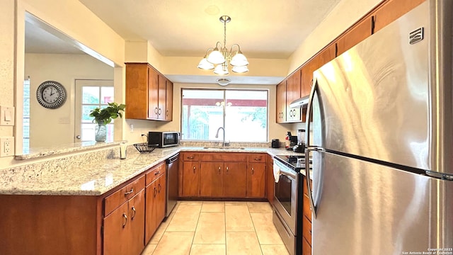 kitchen featuring plenty of natural light, stainless steel appliances, a notable chandelier, and sink