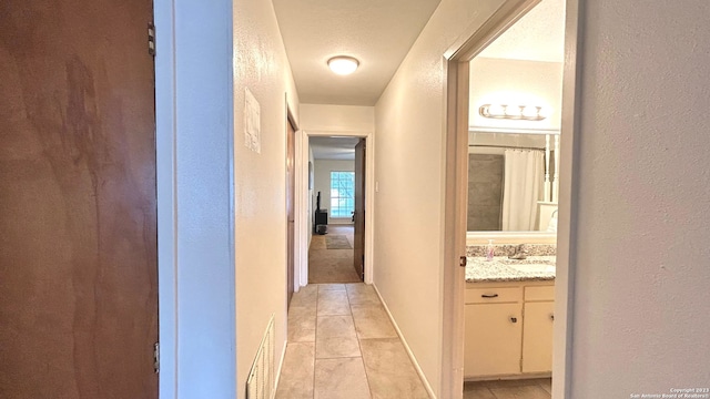 corridor with a textured ceiling and sink