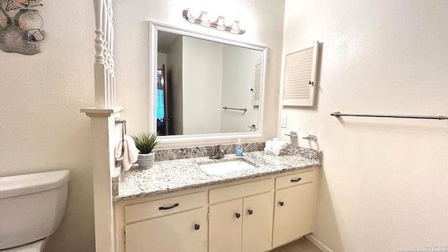 bathroom featuring toilet and vanity