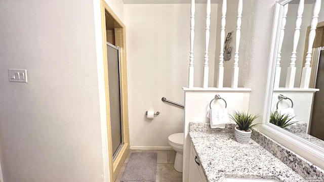 bathroom featuring vanity, toilet, a shower with shower door, and tile patterned flooring