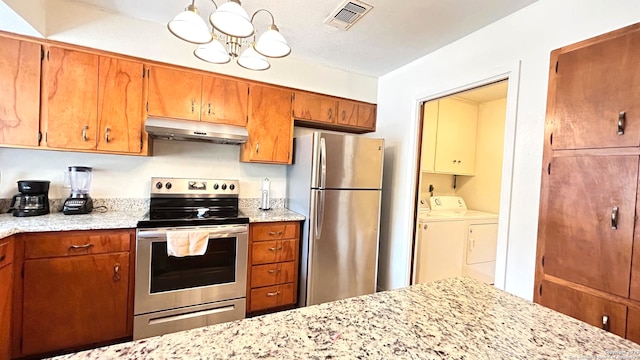 kitchen featuring appliances with stainless steel finishes, a chandelier, light stone counters, and washer and clothes dryer