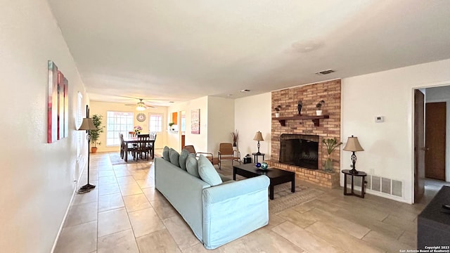 living room with ceiling fan, a fireplace, and light tile patterned flooring