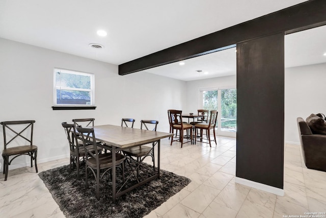 dining space with beamed ceiling