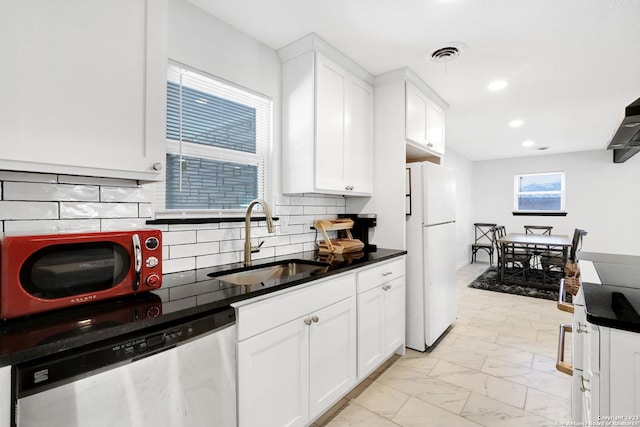 kitchen featuring sink, white cabinetry, backsplash, white refrigerator, and stainless steel dishwasher