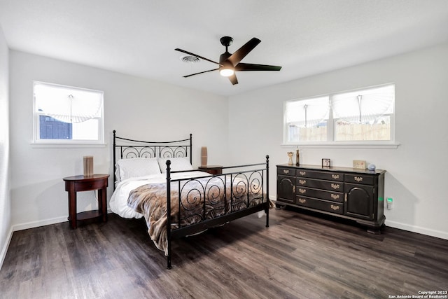 bedroom with multiple windows, dark hardwood / wood-style floors, and ceiling fan