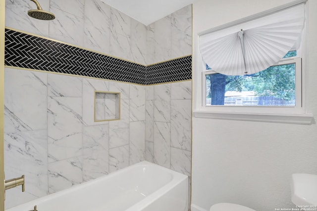 bathroom with tiled shower / bath combo and toilet