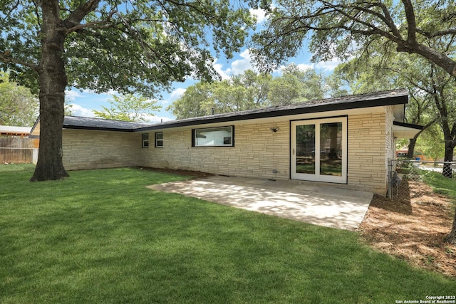 back of property featuring a patio area and a lawn