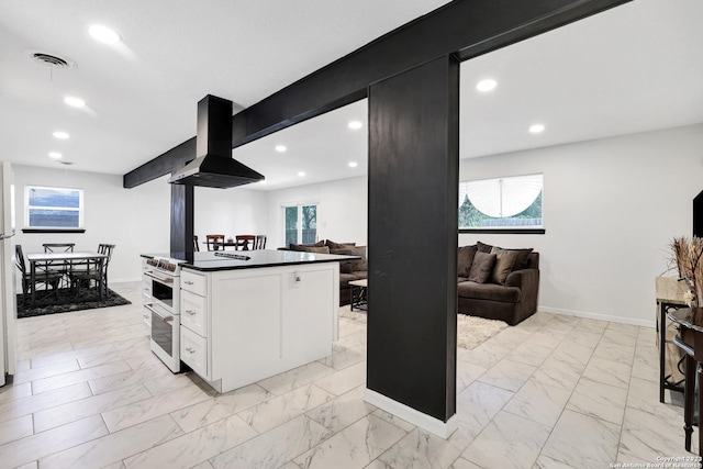 kitchen with white cabinetry, ventilation hood, and range with two ovens