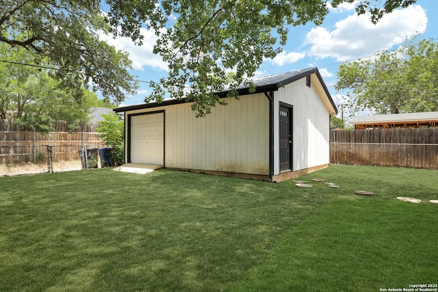 view of outbuilding featuring a garage and a yard