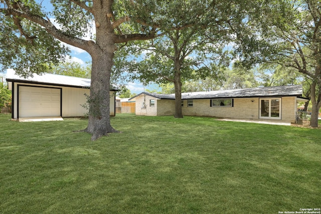 view of yard featuring a garage and a patio