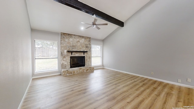 unfurnished living room featuring beam ceiling, ceiling fan, a fireplace, and light hardwood / wood-style flooring