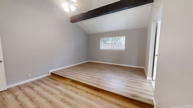 empty room featuring vaulted ceiling with beams and light wood-type flooring