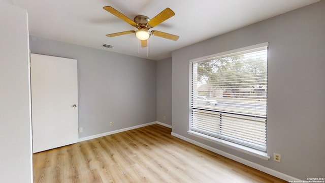 empty room featuring ceiling fan, plenty of natural light, and light wood-type flooring