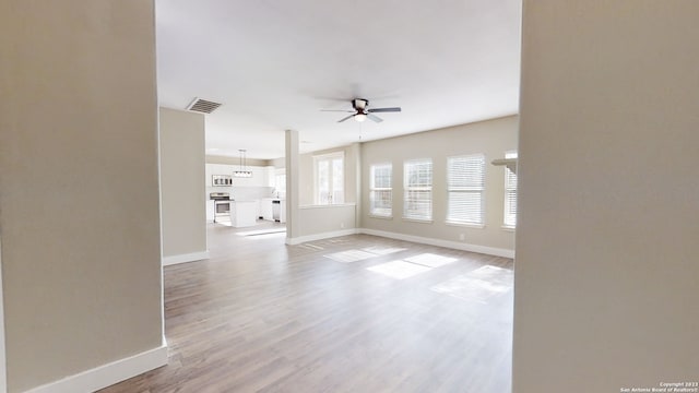 unfurnished living room featuring light wood-type flooring and ceiling fan