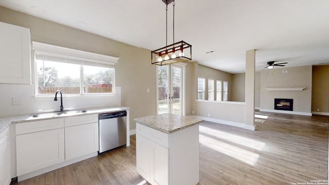 kitchen with white cabinetry, stainless steel dishwasher, sink, and hanging light fixtures