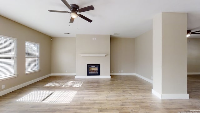 unfurnished living room featuring ceiling fan and light hardwood / wood-style floors