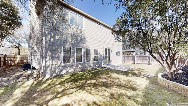 rear view of house featuring a yard and a patio