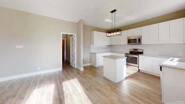 kitchen featuring a kitchen island, appliances with stainless steel finishes, pendant lighting, and white cabinets