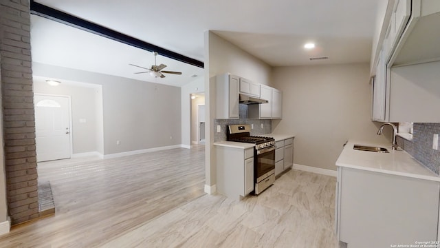 kitchen with sink, ceiling fan, stainless steel range with gas stovetop, lofted ceiling with beams, and decorative backsplash