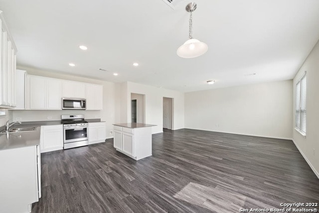 kitchen with white cabinets, dark wood-type flooring, sink, and range