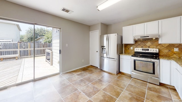 kitchen with appliances with stainless steel finishes, tasteful backsplash, white cabinetry, light tile patterned floors, and light stone countertops