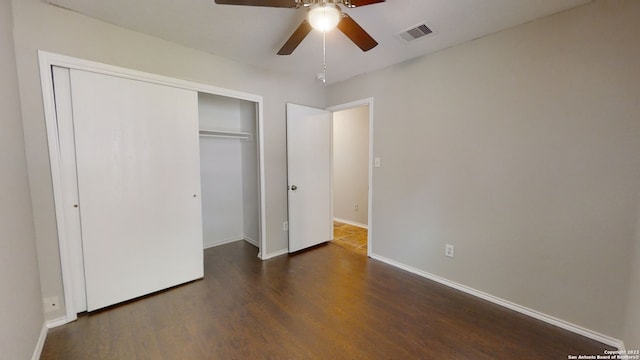 unfurnished bedroom with ceiling fan, dark hardwood / wood-style flooring, and a closet