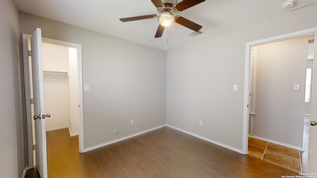 empty room with dark hardwood / wood-style flooring and ceiling fan