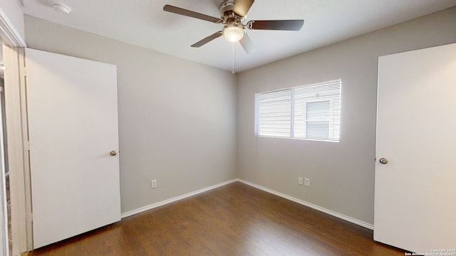 empty room featuring dark wood-type flooring and ceiling fan