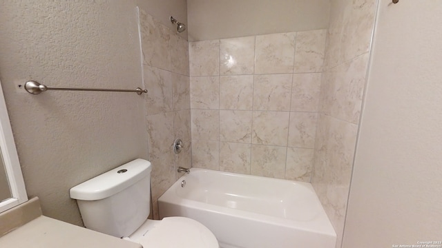 bathroom featuring tiled shower / bath and toilet