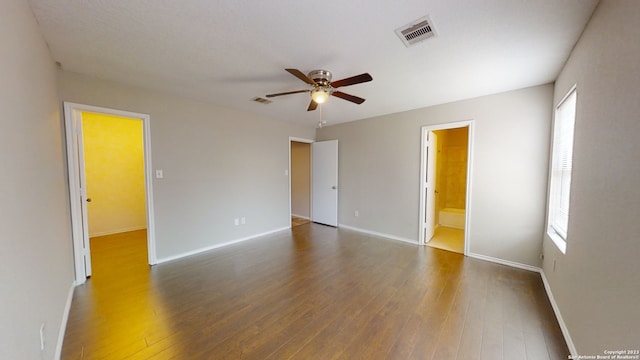 empty room featuring dark wood-type flooring, ceiling fan, and plenty of natural light