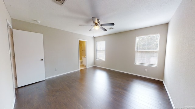 empty room featuring dark wood-type flooring, ceiling fan, and a textured ceiling