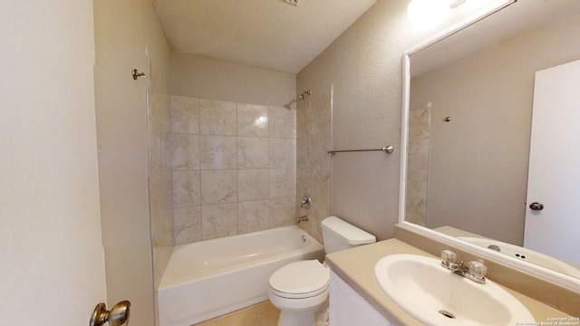 full bathroom with tiled shower / bath combo, vanity, a textured ceiling, and toilet