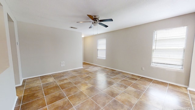 tiled spare room featuring ceiling fan