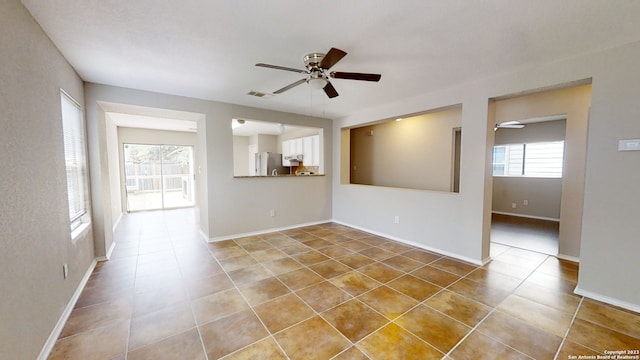 tiled spare room with ceiling fan