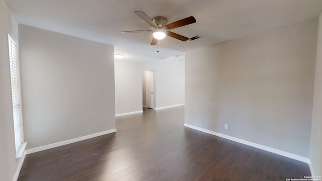 spare room with dark wood-type flooring and ceiling fan