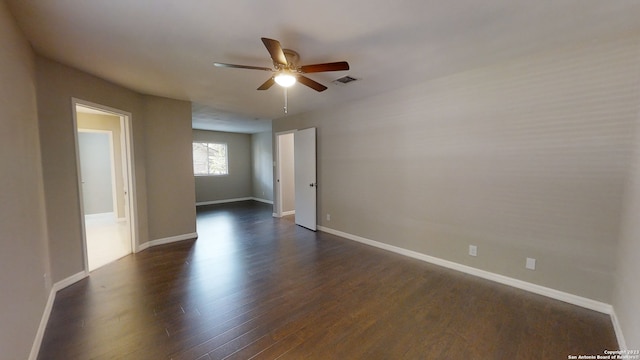 empty room featuring dark wood-type flooring and ceiling fan