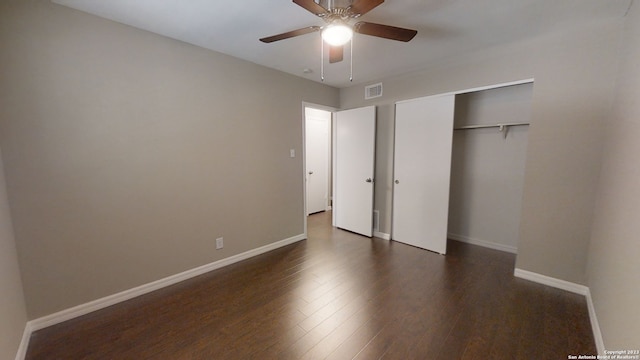 unfurnished bedroom with dark hardwood / wood-style flooring, ceiling fan, and a closet