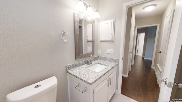 bathroom with hardwood / wood-style flooring, vanity, and toilet